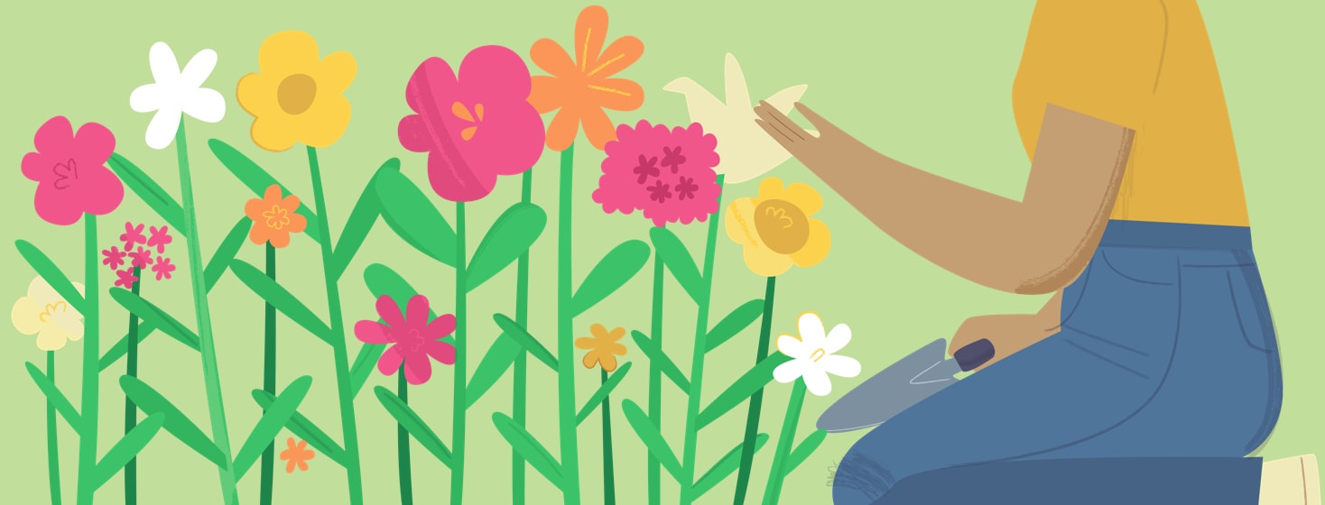 Woman kneeling in her garden admiring the flowers she grew