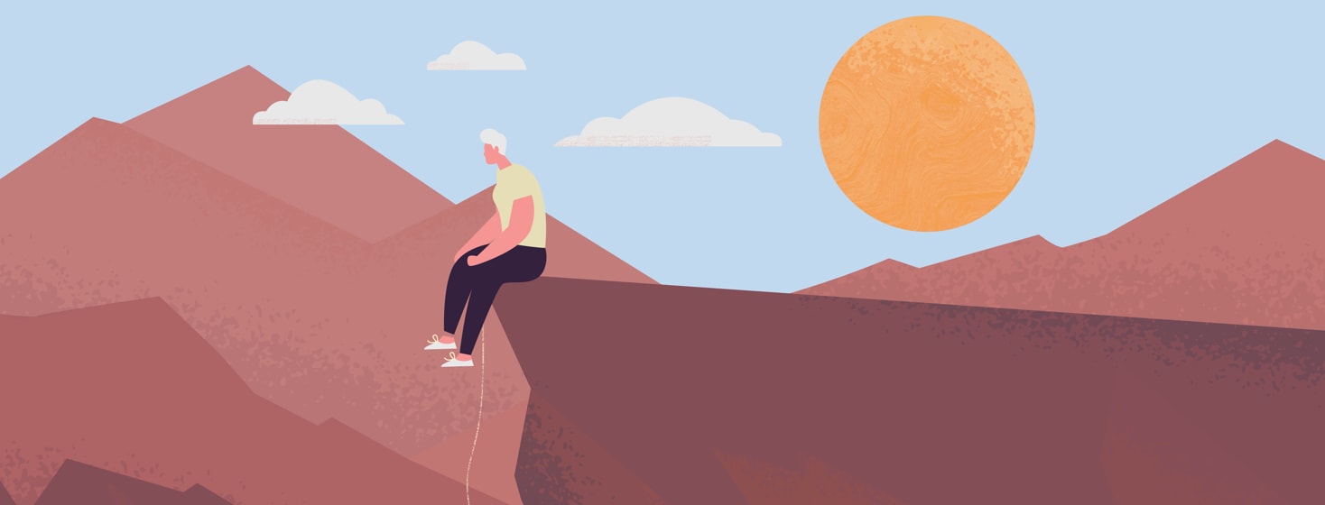 Woman sitting on the edge of a canyon that she has just climbed out of