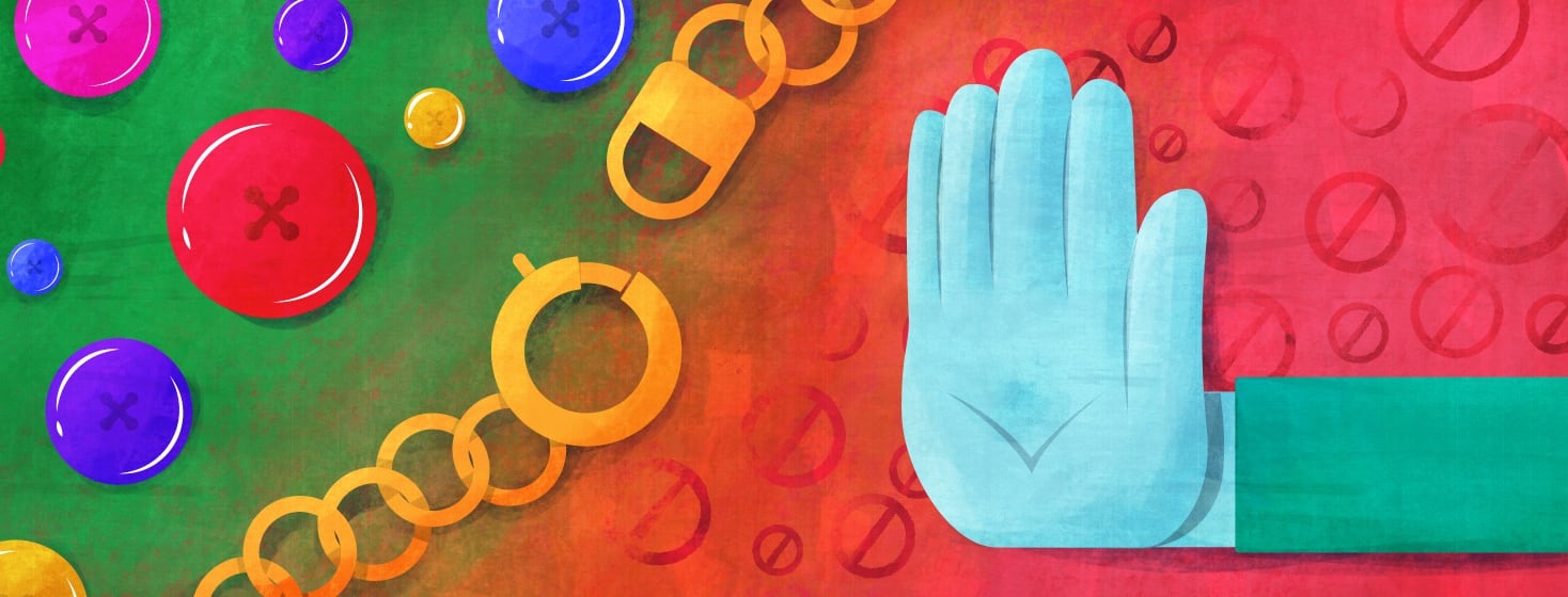 A hand is pushing away clasp necklaces and a pile of buttons.