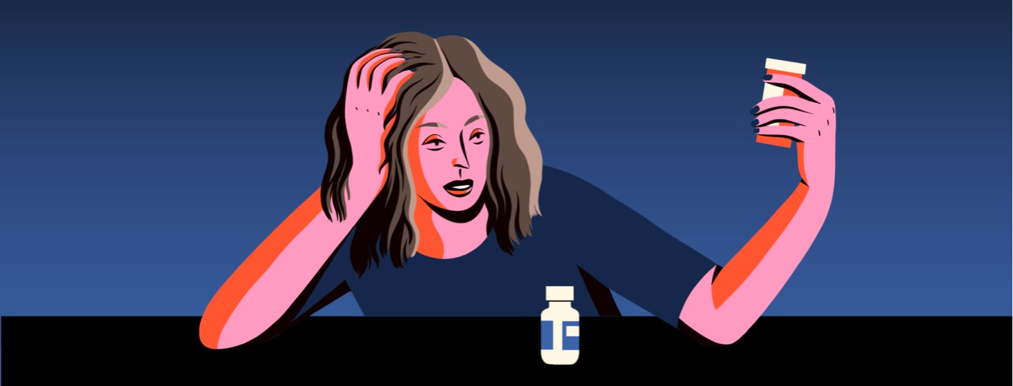 alt=a woman with fatigue examines a bottle of medication.