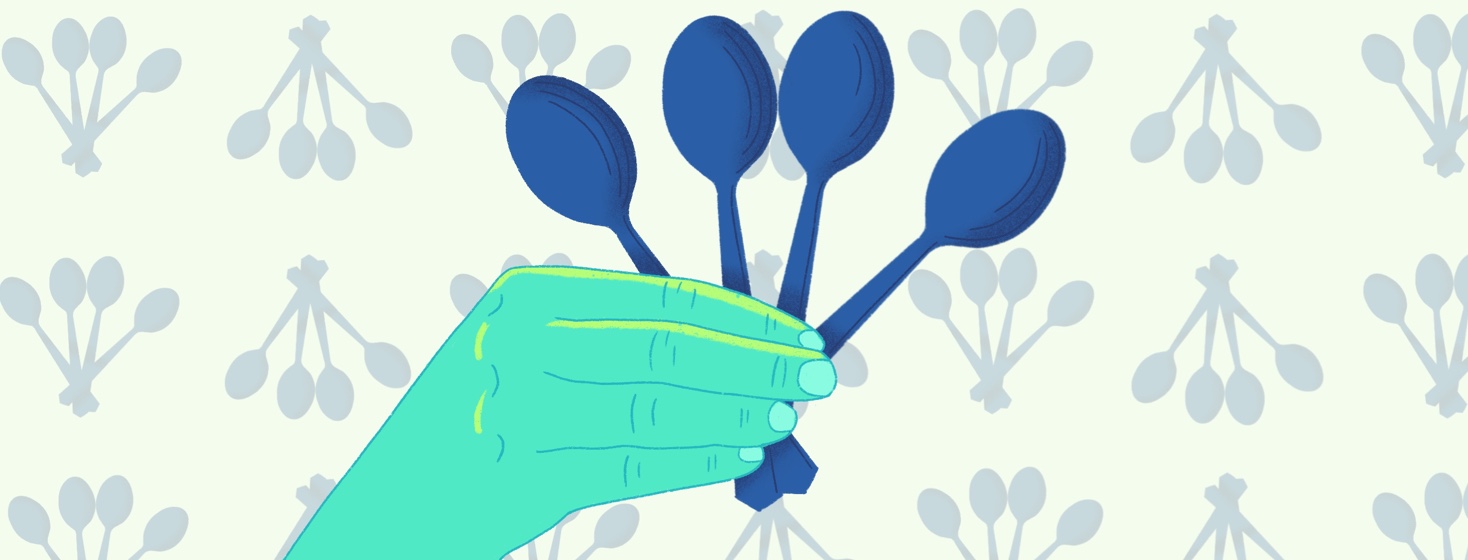 A hand holding four spoons with a spoon patterned background.