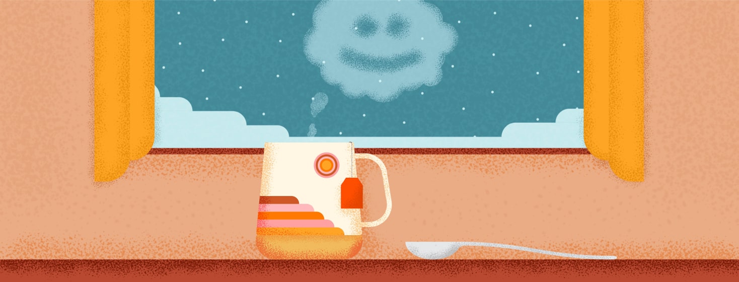 a mug of tea fogging up a window with a smiley face drawn in the steam