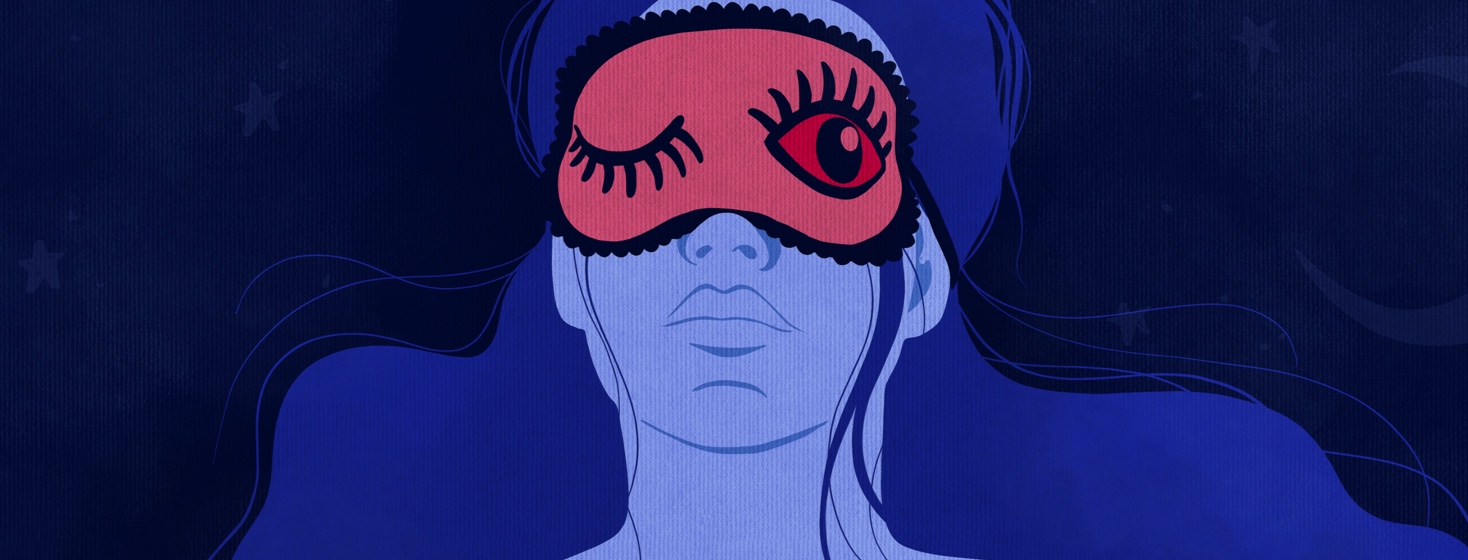 A woman wears an eye mask with two eyes on it, one closed and one open
